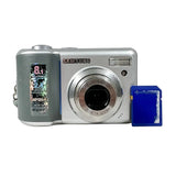 A silver Samsung digital camera with a gray textured grip on the left side, shown next to a small blue card on a white background.