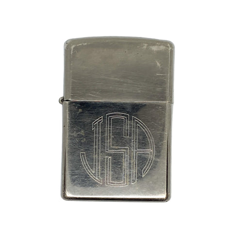 Silver zippo lighter with 'USA' engraving on a white textured background