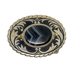 Decorative brooch with black stone and gold-like metalwork on a white background