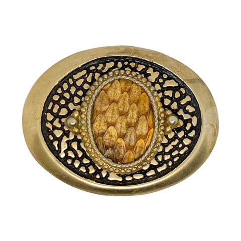 Decorative button with gold and black design on a white background