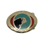 Belt buckle with black silhouette of a cow on a blue and red background, on a white surface