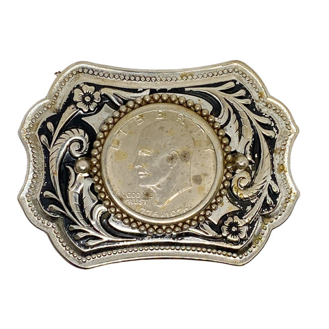 Decorative belt buckle with a coin in the center on a white background