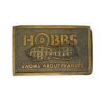 Bronze belt buckle with 'Hobbs Knows About Peanuts' text and peanut design on a white background