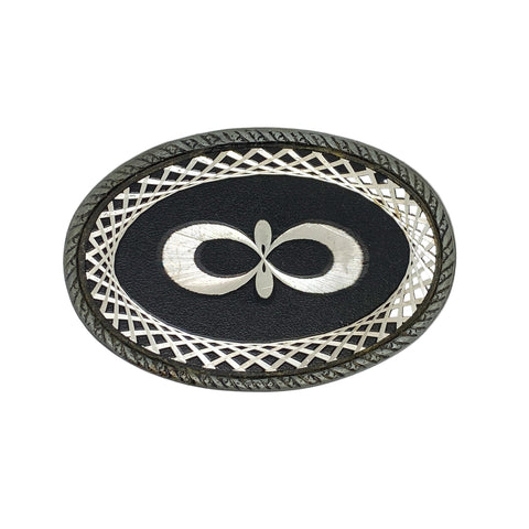 Decorative belt buckle with intricate design on a white background