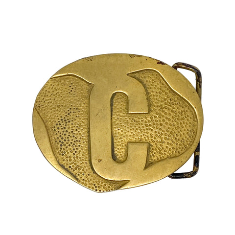 Gold belt buckle with a textured 'C' design on a white background