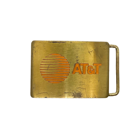 Brass belt buckle with AT&T logo on a white background
