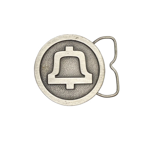 Silver belt buckle with bell design on a light gray background