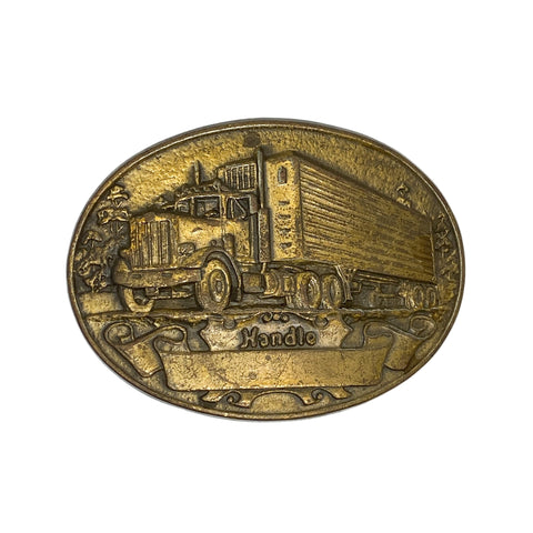 Bronze belt buckle with truck design on a white background