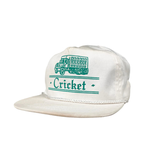 White cap with green text and logo on a gray background