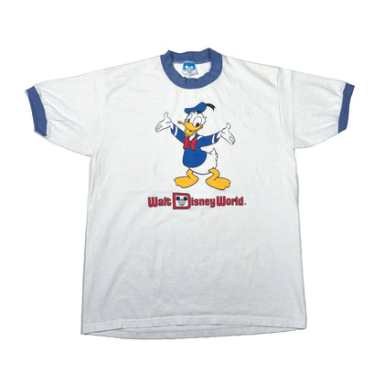 A white ringer t-shirt with blue trim on the collar and cuffs, featuring a graphic of Donald Duck and the text 'Walt Disney World.' printed on the front.