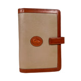 Beige planner with brown leather accents on a white background