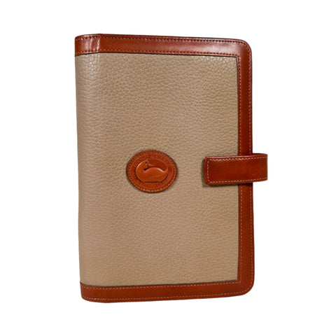 Beige planner with brown leather accents on a white background