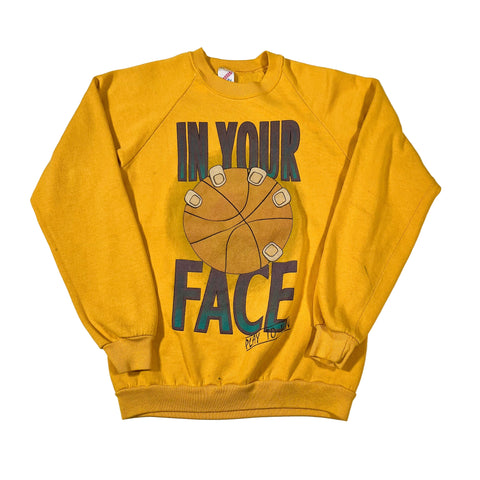 Yellow sweatshirt with graphic design and text on a white background
