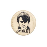 Button badge with a black and white illustration of a person wearing a beanie and the word 'MIKE!' below on a white background.