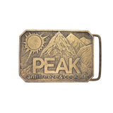 Bronze belt buckle with mountain design and 'PEAK' text on a white background