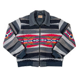 A vintage zip-up knit jacket with a Southwestern geometric pattern in gray, navy, red, yellow, and white, laid flat on a white background.