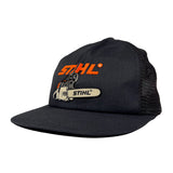 Black cap with orange and white STIHL logo on a light gray background