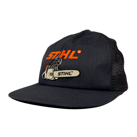 Black cap with orange and white STIHL logo on a light gray background