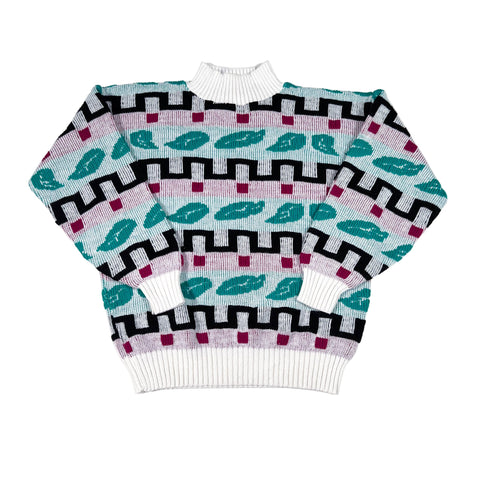 Stack of patterned sweaters on a white background