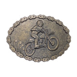 An oval metal belt buckle featuring a raised relief design of a person riding a dirt bike, bordered by a chain-link pattern, shown on a white textured background.