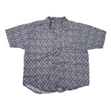 A vintage short-sleeve button-up shirt with an all-over floral print in navy blue and white, laid flat on a white surface.