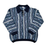 A vintage patterned knit sweater with a dark navy collar, button placket, and ribbed hem, featuring vertical stripes of blue, gray, and white on a light gray background.