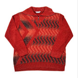 A red knit quarter-zip sweater with a high mock neck collar, laid flat on a white background. The sweater features a textured chevron pattern in red and black across the chest and body.