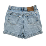 Light blue denim shorts with a brown leather patch on a white background