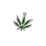 Silver pendant with green leaf design on a white textured background