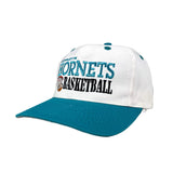 White and blue cap with 'Hornets Basketball' text on a gray background