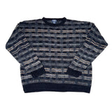 Folded black and gray patterned sweater on a white background