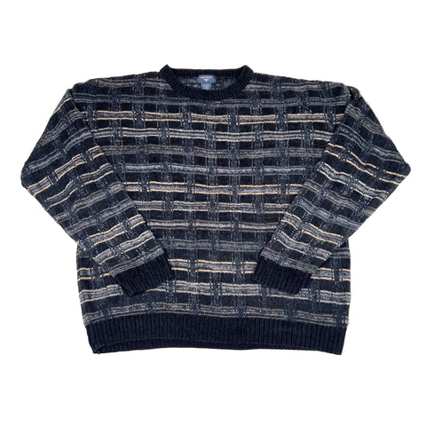 Folded black and gray patterned sweater on a white background