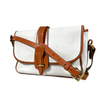 White handbag with brown leather straps on a white background