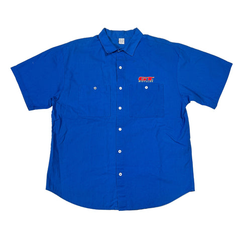 Blue work shirt with a GT Bicycles logo on a white surface