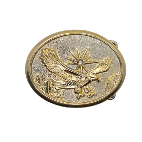 Gold belt buckle with an eagle design on a white background