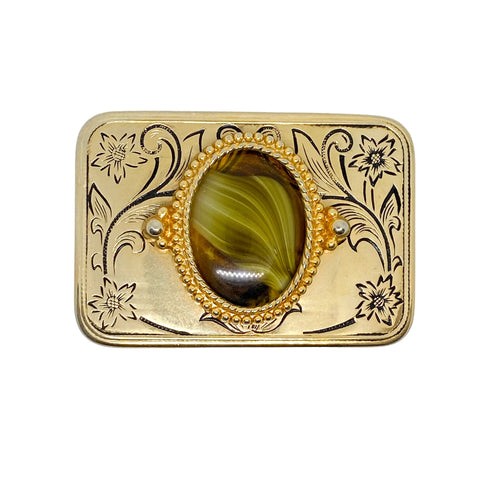 Gold belt buckle with a green stone on a white background