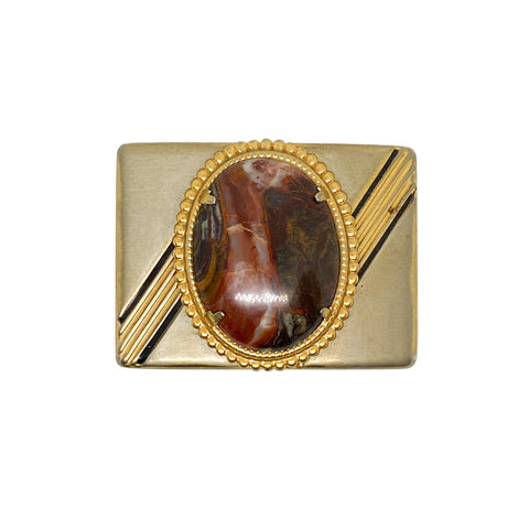 Gold belt buckle with a central stone on a white background