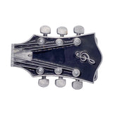 A guitar headstock-shaped belt buckle with a glossy black background and silver metal tuning pegs and treble clef emblem, shown on a white background.