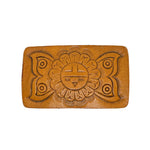Brown leather belt buckle with embossed design on a white background
