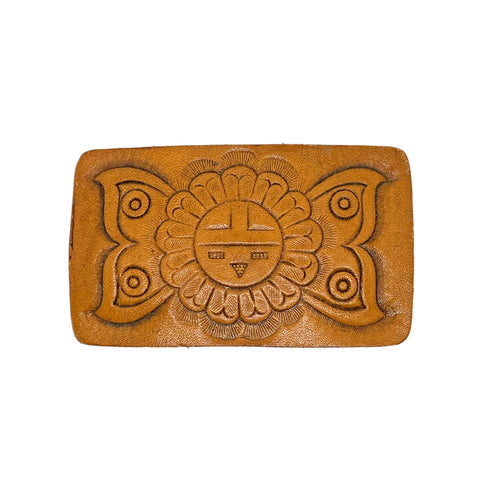 Brown leather belt buckle with embossed design on a white background