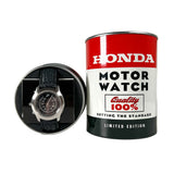 A Honda Motor Watch limited edition presentation set, featuring a round silver-tone watch with a black leather strap inside a circular black display box, next to its signature red, white, and black metal tin packaging.