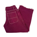 Folded maroon jeans on a white background