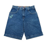 A pair of vintage blue denim shorts with a colorful embroidered patch on the left pocket, laid flat on a white background.