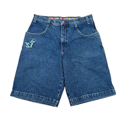 A pair of vintage blue denim shorts with a colorful embroidered patch on the left pocket, laid flat on a white background.