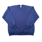 A faded blue crewneck sweatshirt laid flat on a white background, showing signs of wear and tear with small white paint splatters on the front and sleeves.