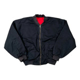 A black nylon bomber jacket with a red interior lining, laid flat on a white background.