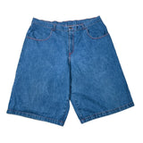 A pair of medium-wash blue denim shorts laid flat on a white fabric background, showing the front pockets and waistband.