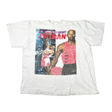 A white vintage graphic t-shirt featuring Michael Jordan, laid flat on a light gray surface. The graphic includes a photo of Michael Jordan in a pink tank top and the word 'JORDAN' in red.