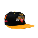 Black and orange cap with racing team logo on a white background