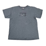 A heather gray short-sleeve t-shirt with a 'JUST DO IT' graphic and a white Nike swoosh on the chest, laid flat on a white surface.